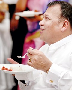 East meets west: Minister Mahinda Samarasinghe tastes a piece of Kiribath (milk rice) with a fork. Pic by MA Pushpa Kumara