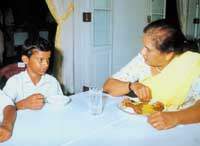 In line with lofty precepts of liberative spirituality, President Chandrika Kumaratunga yesterday invited displaced, terrorised, abused or handicapped children from all parts of the country and from all races and religions to celebrate her 57th birthday with her at President's House. A poor child is seen at table fellowship with his head of state. Pic by Ishara S. Kodikara. 