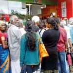 Hatton: Beneficiaries waiting patiently for their turn at a state bank. Pic by Sudath H.M.Hewa
