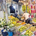 Nuwara Eliya: Fruits and flowers: A tourist makes his picks. Pic by Champa Wikramasighe