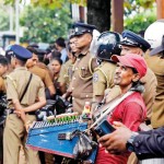 Pettah: Business as usual: A vendor plies his wares amid protests. Pic by Akila Jayawardena